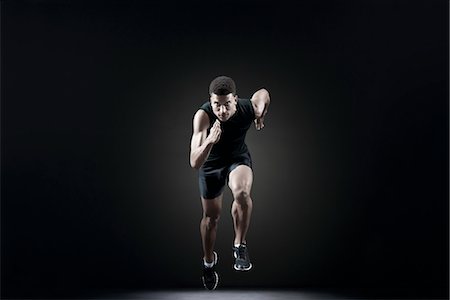 dark background - Male athlete leaving starting line Stock Photo - Premium Royalty-Free, Code: 632-05845239