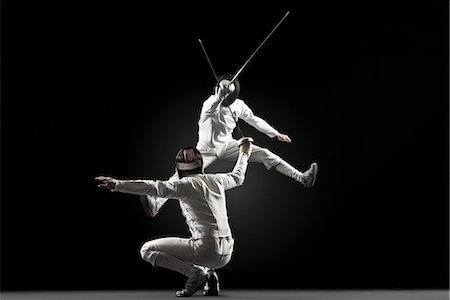 Fencers fencing, one fencer jumping in air Stock Photo - Premium Royalty-Free, Code: 632-05845254