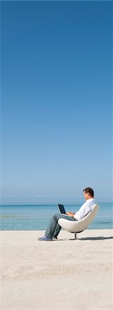 Man using laptop computer at the beach Stock Photo - Premium Royalty-Free, Code: 632-05845308