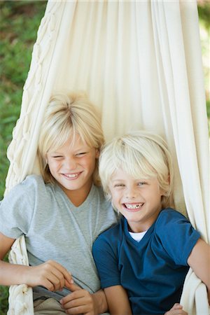 Young brothers sitting together in hammock, portrait Stock Photo - Premium Royalty-Free, Code: 632-05845383
