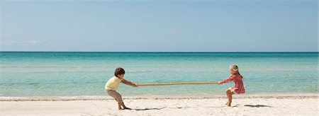 Children playing tug-of-war with bamboo at the beach Stock Photo - Premium Royalty-Free, Code: 632-05845453