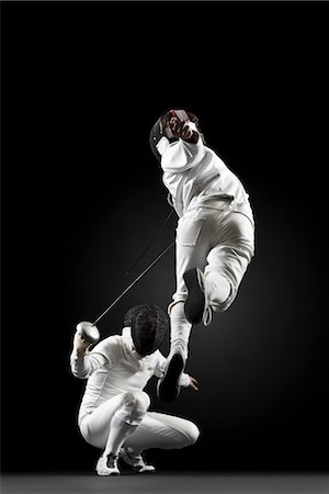 Fencers fencing, one fencer jumping in air Foto de stock - Sin royalties Premium, Código: 632-05845466