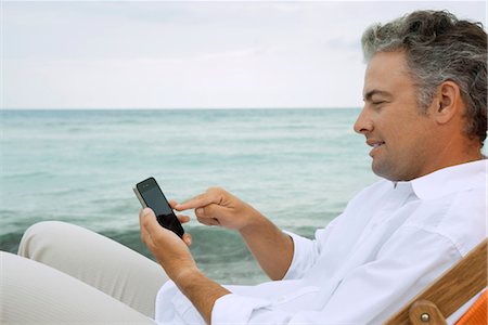 smartphone at beach - Man using smartphone at the beach Stock Photo - Premium Royalty-Free, Code: 632-05845472