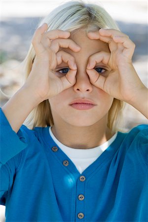 Boy forming circles with fingers around eyes Stock Photo - Premium Royalty-Free, Code: 632-05845500