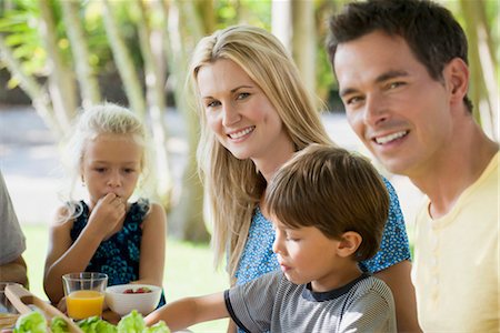 Family having meal outdoors, focus on young woman Stock Photo - Premium Royalty-Free, Code: 632-05845572