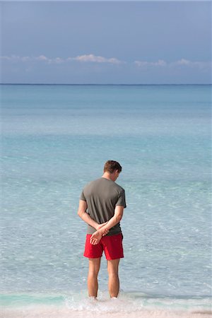 simsearch:696-03402108,k - Man standing ankle deep in water contemplating ocean, rear view Stock Photo - Premium Royalty-Free, Code: 632-05845629