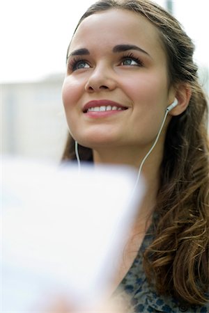 simsearch:632-06779260,k - Young woman listening to music with earphones Foto de stock - Sin royalties Premium, Código: 632-05845666