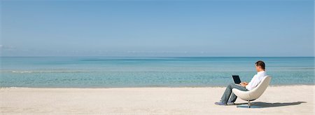 panorama - Homme utilisant un ordinateur portable à la plage Photographie de stock - Premium Libres de Droits, Code: 632-05845695