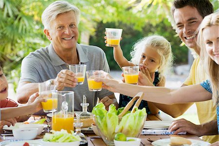 succo d'arancia - Multi-generation family toasting with orange juice outdoors, portrait Fotografie stock - Premium Royalty-Free, Codice: 632-05845743