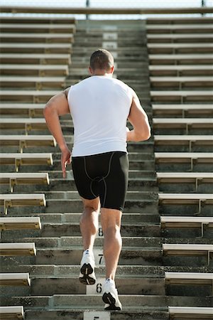 Homme en cours d'exécution des étapes dans le stade, vue arrière Photographie de stock - Premium Libres de Droits, Code: 632-05991111