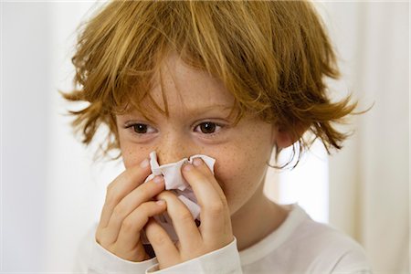 freckled boy - Boy blowing nose on tissue Stock Photo - Premium Royalty-Free, Code: 632-05991126