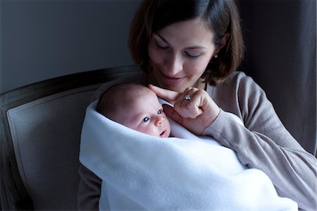 holding baby wrapped in blanket