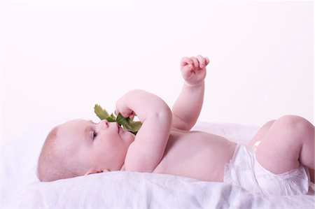 Baby holding leaves against face Stock Photo - Premium Royalty-Free, Code: 632-05991208