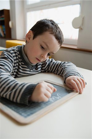 Boy writing on chalkboard Stock Photo - Premium Royalty-Free, Code: 632-05991245