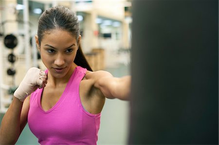 punch - Young woman punching heavy bag Stock Photo - Premium Royalty-Free, Code: 632-05991301