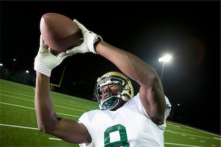 football (american ball) - Football player catching ball Foto de stock - Sin royalties Premium, Código: 632-05991468