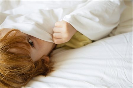 Boy hiding under bedsheet Foto de stock - Royalty Free Premium, Número: 632-05991557