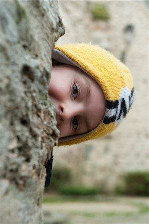 Boy peeking from behind tree Stock Photo - Premium Royalty-Free, Code: 632-05991624