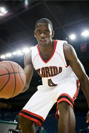 Basketball player dribbling basketball, low angle view Foto de stock - Sin royalties Premium, Código: 632-05991638