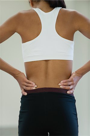 female sports bra - Woman with backache, rear view Stock Photo - Premium Royalty-Free, Code: 632-05991761