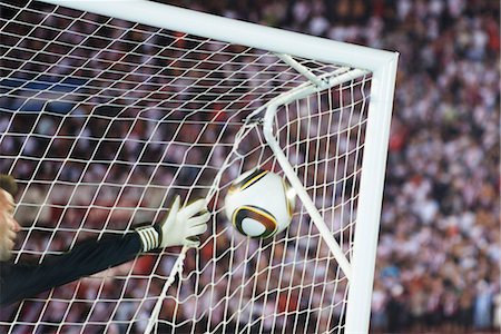 Soccer goalkeeper diving to block ball Foto de stock - Sin royalties Premium, Código: 632-05991799