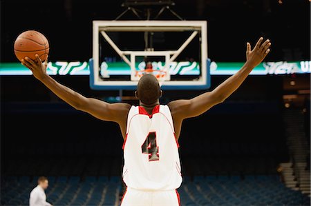 Basketball player standing in basketball court with arms outstretched, rear view Stock Photo - Premium Royalty-Free, Code: 632-05991814