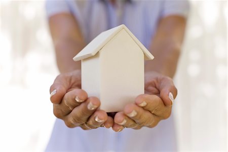 person cupping hands - Woman holding small model house, cropped Stock Photo - Premium Royalty-Free, Code: 632-05991858