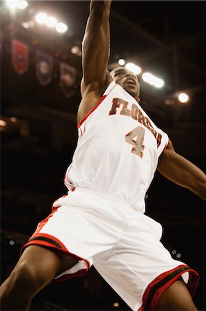Basketball player jumping in air, low angle view Foto de stock - Sin royalties Premium, Código: 632-05991932