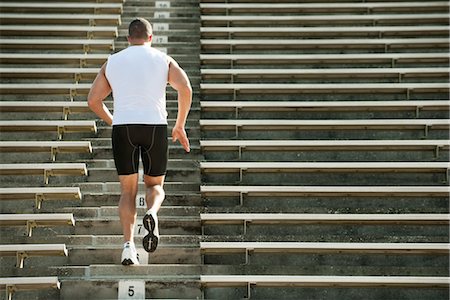 step aerobic - Man running up steps in stadium, rear view Foto de stock - Sin royalties Premium, Código: 632-05991942