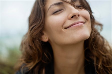 eyes closed - Smiling young woman with eyes closed Stock Photo - Premium Royalty-Free, Code: 632-05991977
