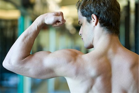 simsearch:632-05991270,k - Young man flexing bicep muscles Stock Photo - Premium Royalty-Free, Code: 632-05992015