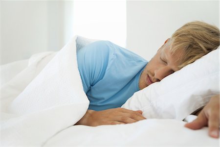 dormire più a lungo - Young man sleeping in bed Fotografie stock - Premium Royalty-Free, Codice: 632-05992012