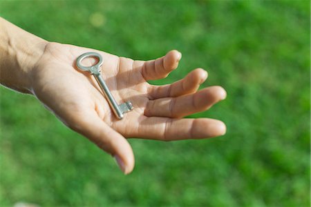 Woman holding key in palm Foto de stock - Royalty Free Premium, Número: 632-05992201