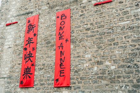 Couplets in with Chinese and Western scripts hanging on brick wall Stock Photo - Premium Royalty-Free, Code: 632-05992263