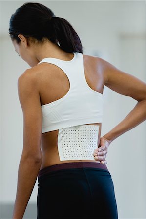 Woman with bandage on lower back, rear view Foto de stock - Sin royalties Premium, Código: 632-05992319