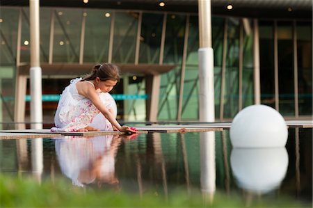 pond - Girl placing flower on surface of water Stock Photo - Premium Royalty-Free, Code: 632-06029280