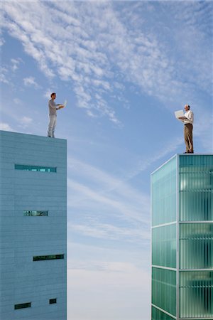 Men standing on top of high rise buildings, using laptop computers Stock Photo - Premium Royalty-Free, Code: 632-06029309