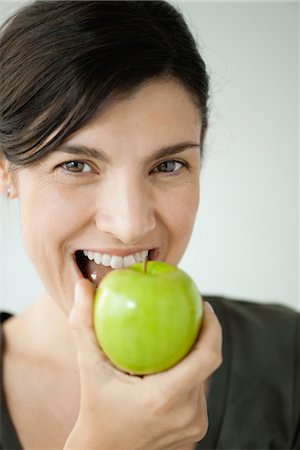 Mid-adult woman biting into apple Foto de stock - Royalty Free Premium, Número: 632-06029329