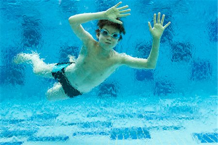 Boy swimming underwater in swimming pool Foto de stock - Sin royalties Premium, Código: 632-06029386