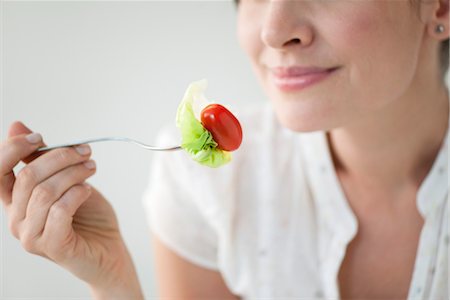 salad on fork - Femme manger salade, recadrée Photographie de stock - Premium Libres de Droits, Code: 632-06029421