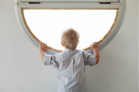Little boy looking through window, rear view Foto de stock - Sin royalties Premium, Código: 632-06029451