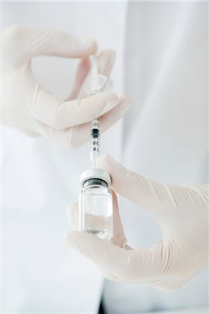 Extracting liquid from vial with syringe Stock Photo - Premium Royalty-Free, Code: 632-06029464