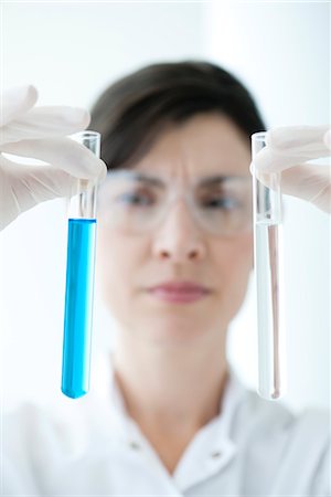 Scientifique brandissant des tubes à essai contenant un liquide Photographie de stock - Premium Libres de Droits, Code: 632-06029486