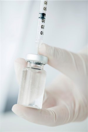 Extracting liquid from vial with syringe Stock Photo - Premium Royalty-Free, Code: 632-06029500