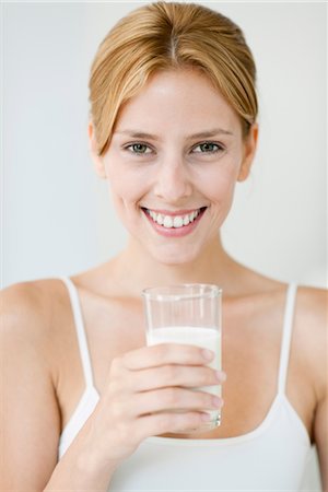 Young woman holding glass of milk, portrait Fotografie stock - Premium Royalty-Free, Codice: 632-06029594
