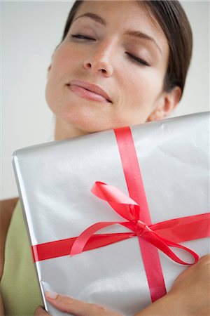 simsearch:632-06029820,k - Woman embracing gift, eyes closed Stock Photo - Premium Royalty-Free, Code: 632-06029591