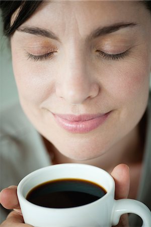 simsearch:632-05553600,k - Mid-adult woman smelling cup of coffee Foto de stock - Sin royalties Premium, Código: 632-06029650