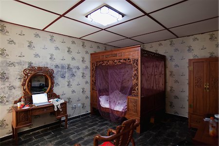 Bedroom decorated with ornately carved furniture and canopy bed Stock Photo - Premium Royalty-Free, Code: 632-06029687