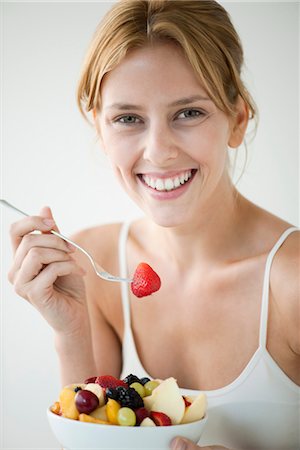 Young woman eating fruit salad, portrait Foto de stock - Sin royalties Premium, Código: 632-06029697