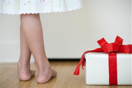 simsearch:632-06029820,k - Girl standing beside wrapped gift, low section Stock Photo - Premium Royalty-Free, Code: 632-06029754